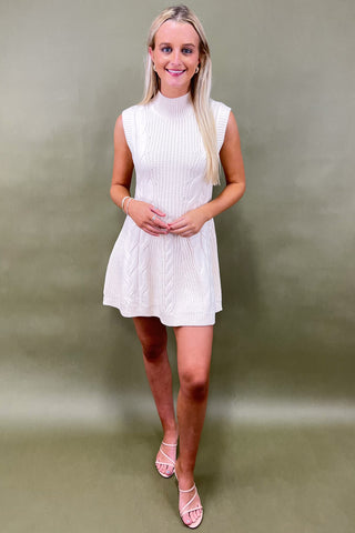 Woman wearing a white dress against a plain background