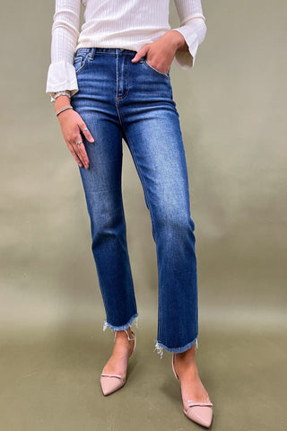 Person wearing blue jeans and pink shoes on a plain background