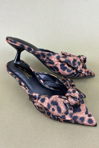 Leopard print high-heeled shoes on a light green background