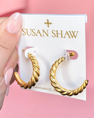 Gold hoop earrings on a Susan Shaw branded card against a pink background