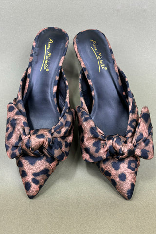 Pair of leopard print shoes with bow details on a gray background