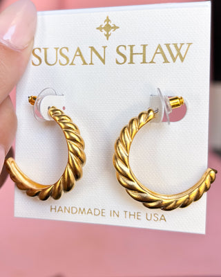 Gold hoop earrings on a 'Susan Shaw' branded card with a pink background
