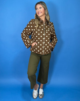 Brown polka dot zip-up jacket with a collared neckline, long sleeves, front pockets, and a relaxed fit.