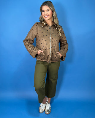Brown polka dot zip-up jacket with a collared neckline, long sleeves, front pockets, and a relaxed fit.