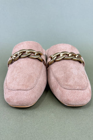 Pair of pink loafers with gold chain details on a light gray background