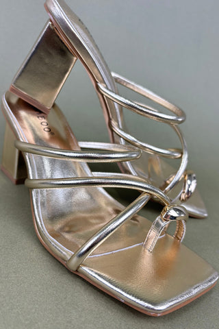Silver high-heeled shoe with open toe on a gray background