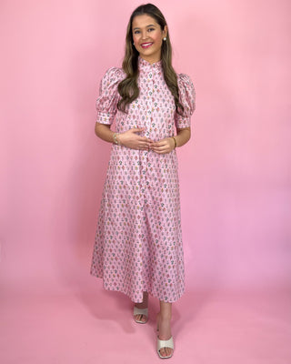 Woman wearing a pink floral dress against a pink background