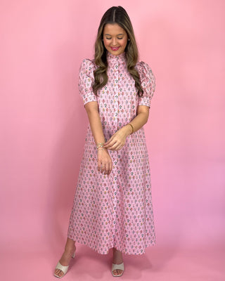 Woman wearing a pink floral dress against a pink background