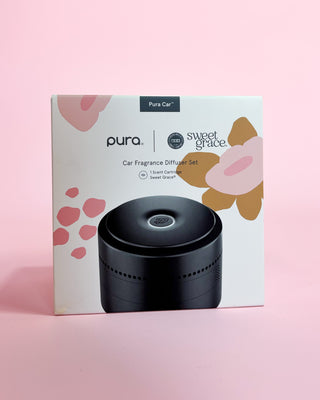 Pura car fragrance diffuser set packaging with floral designs on a pink background