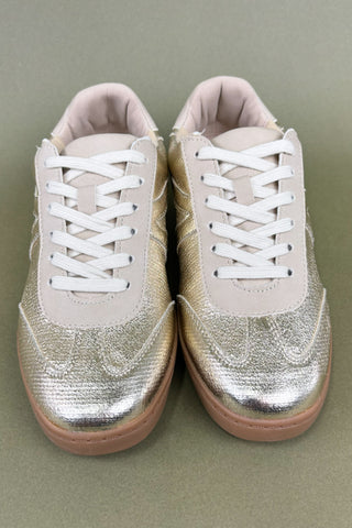 Pair of sneakers with metallic silver accents on a neutral background