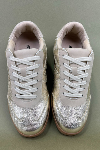 Pair of light gray sneakers with white laces on a green background