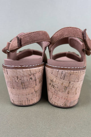 Pair of pink sandals with cork sole on a light gray background
