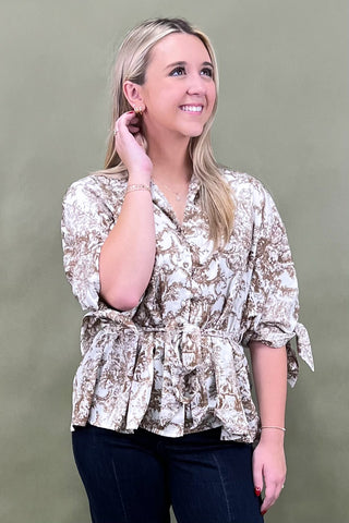 Woman wearing a floral blouse against a plain background