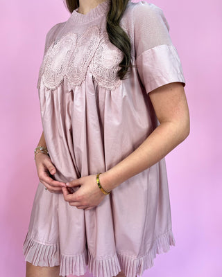 Pink dress with lace details on a pink background