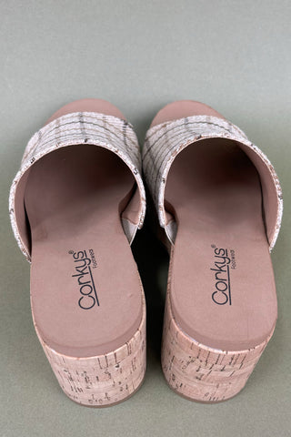 Pair of pink sandals with cork sole on a gray background