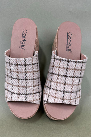 Plaid patterned slides with pink soles on a gray background