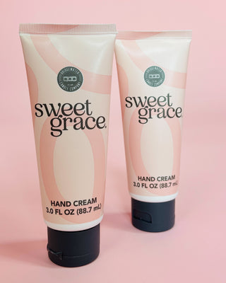 Two tubes of sweet grace hand cream on a pink background
