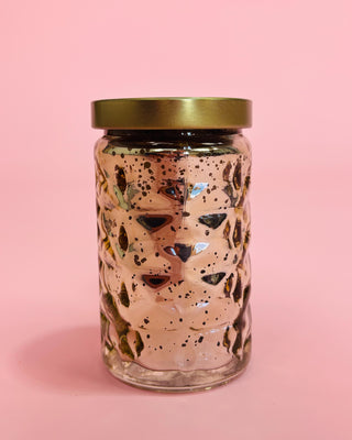 Glass jar with terrazzo pattern and gold lid on a pink background