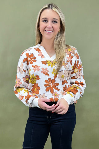 Woman wearing a floral sweater against a green background