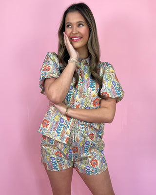 Woman wearing a colorful floral outfit against a pink background