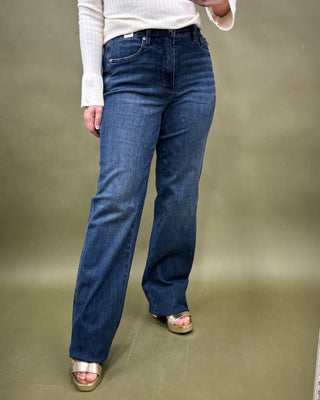 Person wearing blue jeans on a plain background