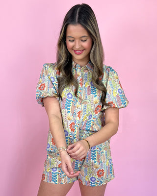 Woman wearing a colorful floral dress against a pink background