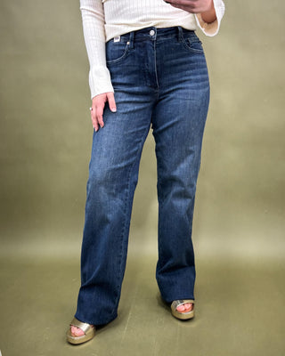 Person wearing blue jeans on a plain background