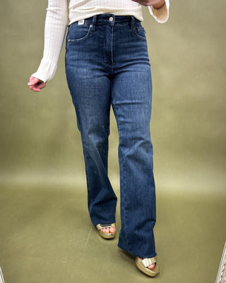 Person wearing blue jeans on a plain background