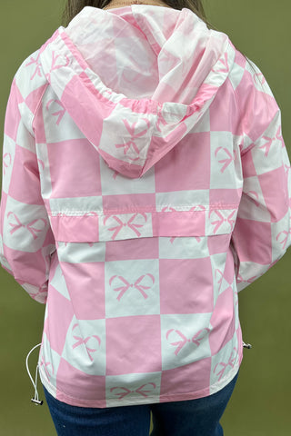 Pink and white checkered jacket with bow pattern on a green background