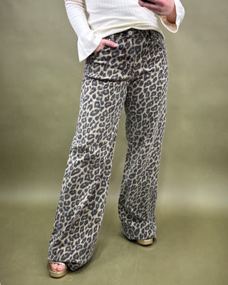 Person wearing leopard print pants on a plain background