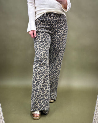 Person wearing leopard print pants on a plain background