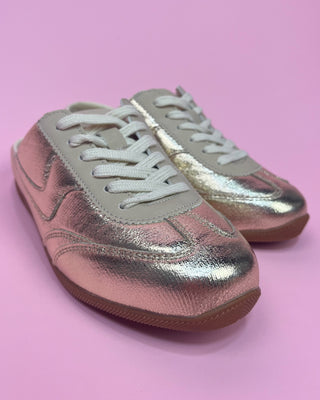 Metallic gold lace-up sneakers with a shiny textured finish, cream accents, white laces, and gum rubber soles. Stylish low-top fashion sneakers that combine sporty comfort with eye-catching metallic shine for casual everyday wear.