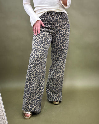 Person wearing leopard print pants on a plain background