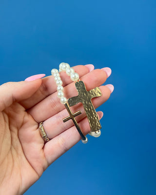 Two-piece gold cross and faux pearl stretch bracelet set featuring hammered and polished gold cross accents on white pearl bead bracelets.