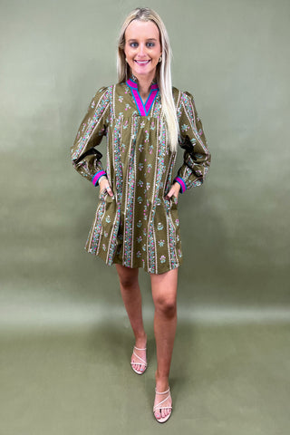 Woman wearing a patterned dress against a green background