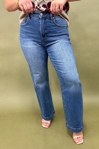 Person wearing blue jeans on a green background