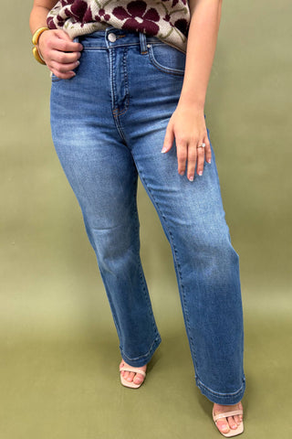 Person wearing blue jeans on a green background