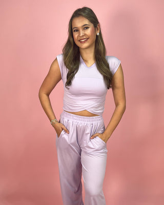 Woman wearing a light purple outfit against a pink background
