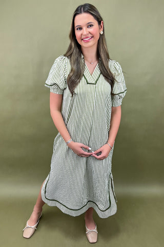Woman wearing a green and white striped dress against a green background