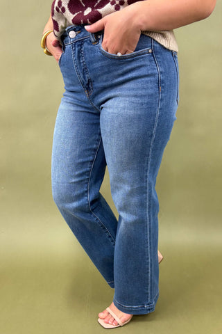 Person wearing blue jeans on a green background