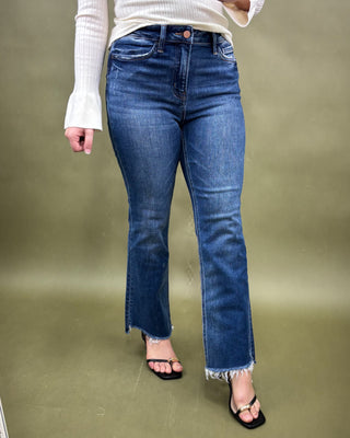 Person wearing blue jeans on a plain background