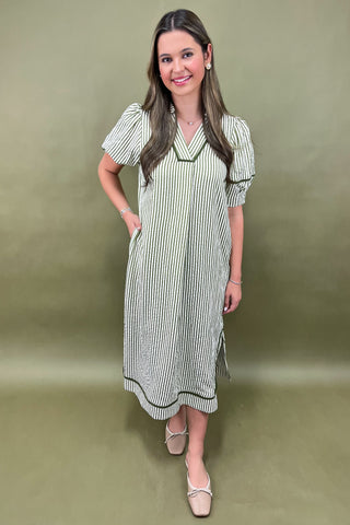 Woman wearing a striped dress against a green background