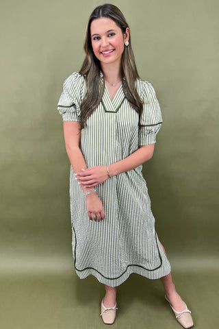 Woman wearing a striped dress against a green background