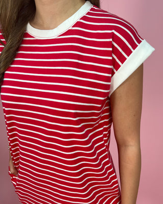 Red and white striped shirt worn by a person on a pink background
