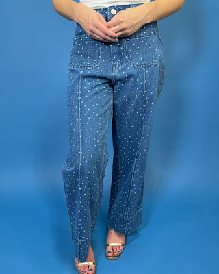 A person wearing blue denim jeans with a white polka-dot pattern