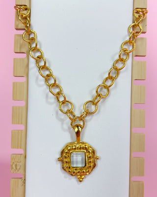 Gold necklace with a pendant on a white background