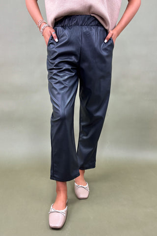 Person wearing navy pants on a plain background