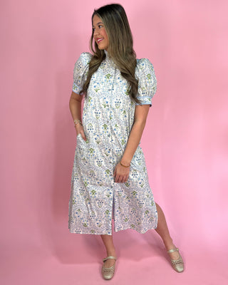 Woman wearing a floral dress against a pink background