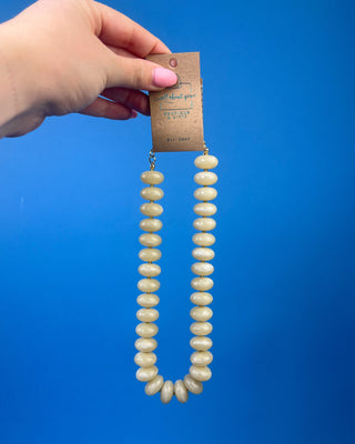Chunky marbled resin bead statement necklace with oversized cream beads, gold-tone spacer accents, adjustable clasp closure, and lightweight design, available in multiple colors.