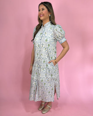 Woman wearing a floral dress against a pink background